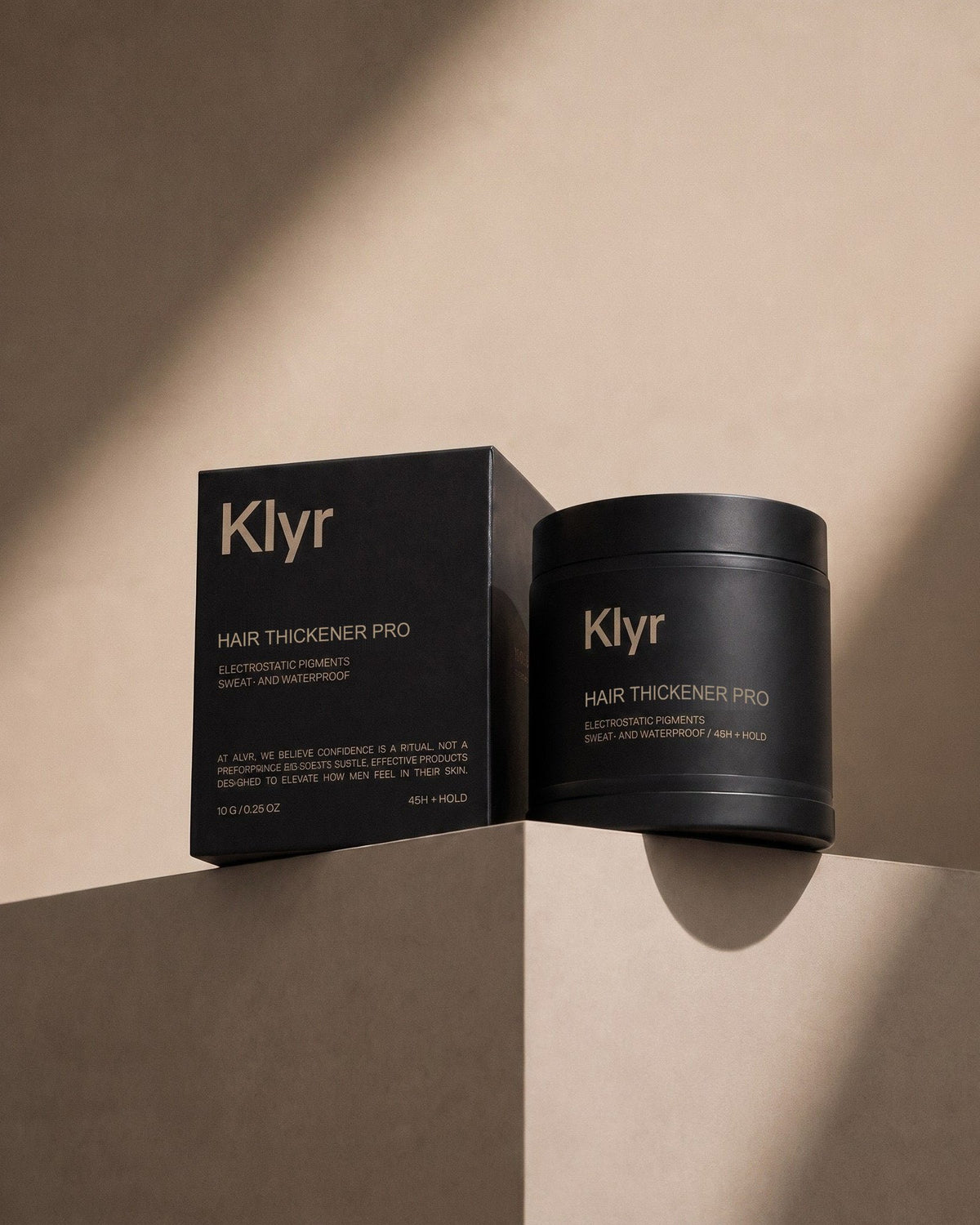 Klyr Hair Thickener Pro jar and box on a beige display plinth